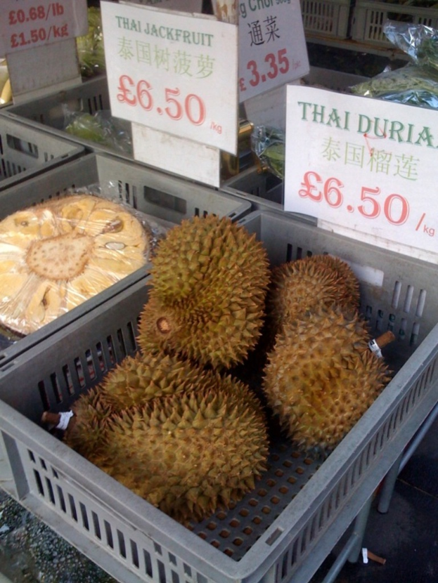 Fruits in trays with price boards displayed nearby.