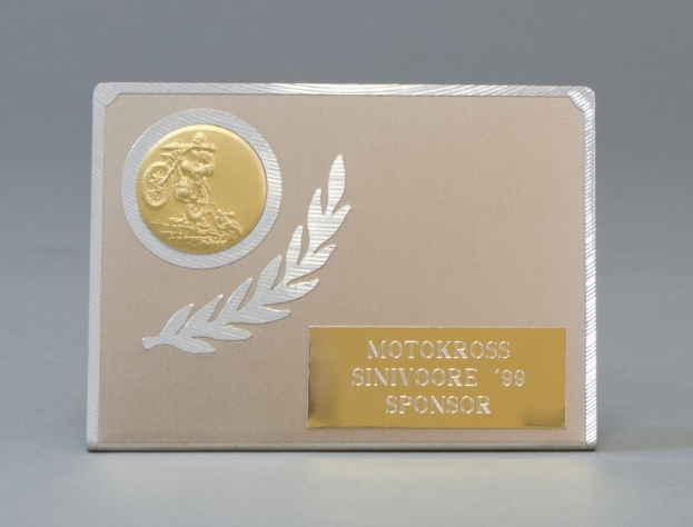 Eine goldene und silberne Visitenkarte mit einem Lorbeerkranz-Design, das in der Mitte des Bildes positioniert ist und Text enthält, der wahrscheinlich den Namen des Sponsors darstellt.