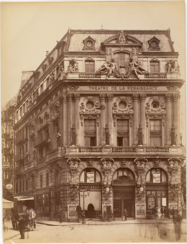 Altes Foto des Théâtre de la Renaissance in Paris mit seiner prunkvollen Fassade mit Fenstern, Säulen, Bögen und Skulpturen, mit einigen Menschen und Fahrzeugen auf der Straße und dem Himmel im Hintergrund.