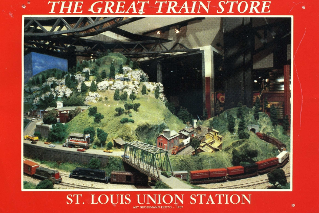 Ein Plakat mit einer Eisenbahn, die über eine Brücke mit Trägernkonstruktion fährt, umgeben von Pflanzen, Häusern und Hügeln.