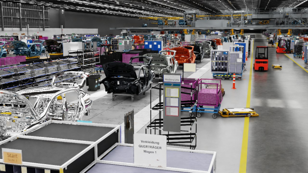 Ein großes Fabrikinnere mit zahlreichen Autos auf der Fertigungsstraße, Metallobjekte auf beiden Seiten und einige Fahrzeuge auf dem Boden, mit Lampen an der Decke und einer Wand im Hintergrund, wahrscheinlich ein Volkswagen-Werk in Deutschland.