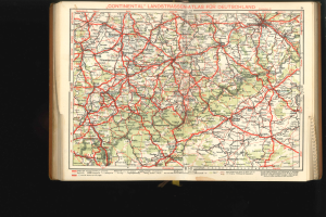 Offenes Buch mit einer detaillierten Karte von Deutschlands Straßen und Autobahnen auf schwarzem Hintergrund.