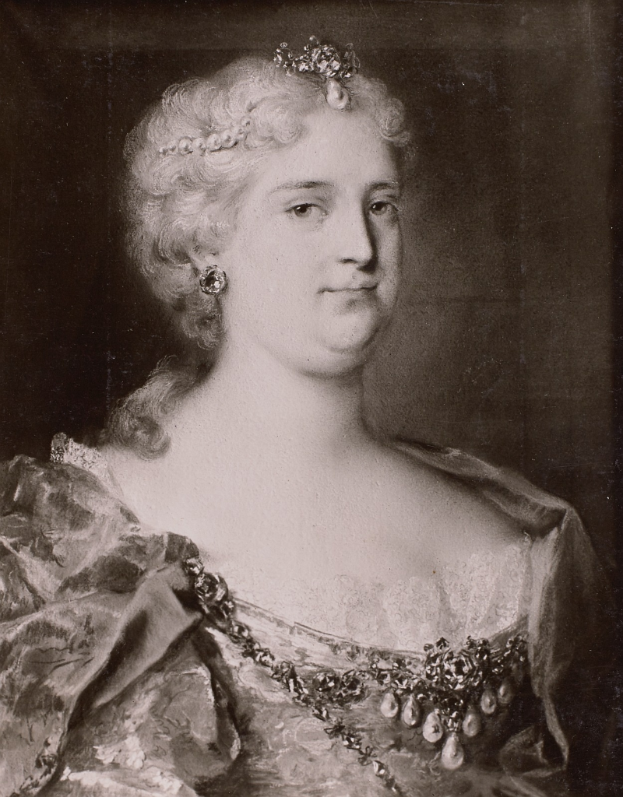 Ein Schwarz-Weiß-Foto einer Frau in einem hellen Kleid mit hohem Ausschnitt und langen Ärmeln, die eine Tiara und eine zarte Kette trägt, ihr Haar ist elegant hochgesteckt und sie blickt mit einem friedlichen und anmutigen Ausdruck in die Ferne.