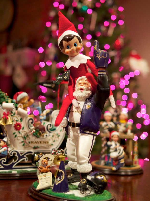 Spielfiguren stehen im Vordergrund, beleuchteter Weihnachtsbaum im Hintergrund.