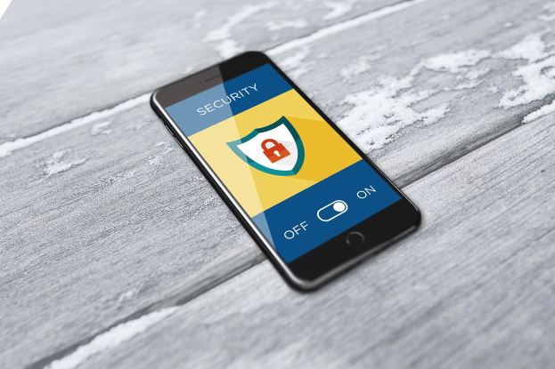 Ein Smartphone mit einem Sicherheits-Symbol und dem Wort "Sicherheit" auf dem Bildschirm, das auf einer hölzernen Oberfläche mit einem Wasserzeichen in der linken oberen Ecke liegt.