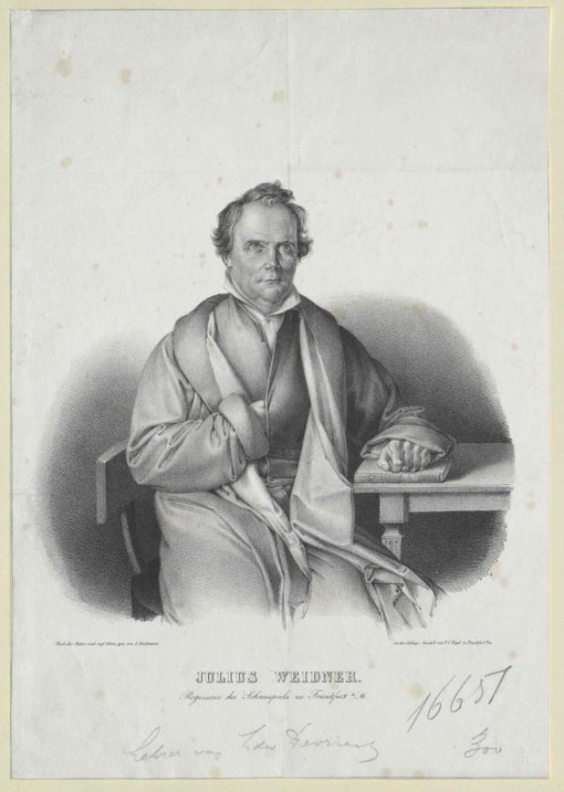 Porträt von Julius Weidner, einem deutschen Philosophen, der an einem Tisch sitzt und ernst dreinschaut, mit Krawatte und Anzug, die Hände auf dem Tisch ruhend und direkt in die Kamera schauend, mit Text auf dem Papier vor ihm.