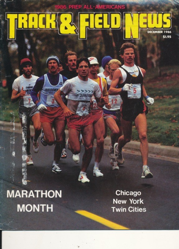 Ein Plakat, das eine Gruppe von Läufern auf einer Straße mit Bäumen und Gras zeigt, mit der Überschrift "Track & Field News Marathon Month."