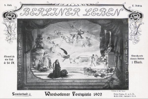 Schwarz-weiß-Foto einer Bühne mit Darstellern in traditioneller deutscher Tracht während der "Wiesbadener Festspiele 1902", umgeben von einem applaudierenden Publikum und bunten Bühnendekorationen.